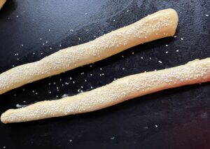 Posmarowane jajkiem i obsypane sezamem paszteciki przed pieczeniem