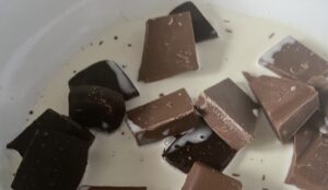 Podgrzewanie śmietanki do polewy czekoladowej do makowca w cieście kruchym.