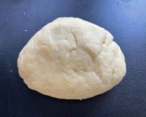 Zagniatanie kruchego ciasta do makowca w cieście.