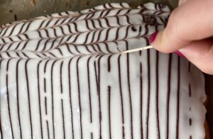 Ozdabianie makowca warstwowego lukrem i czekoladowymi paseczkami