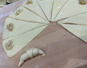 Zwijamy ciasto tworząc rogaliki z jabłkami