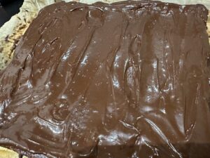 Równomierne nakładanie polewy czekoladowej na seromakowiec bez spodu