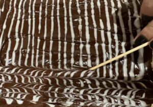 Dekoracyjny wzór na polewie seromakowca bez spodu wykonany patyczkiem