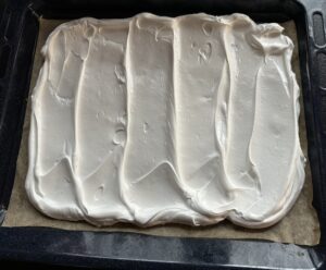 Rozprowadzanie bezy na blaszce pod roladę bezową