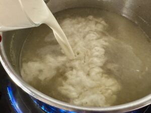 dodawanie śmietanki do sosu serowego do pulpecików