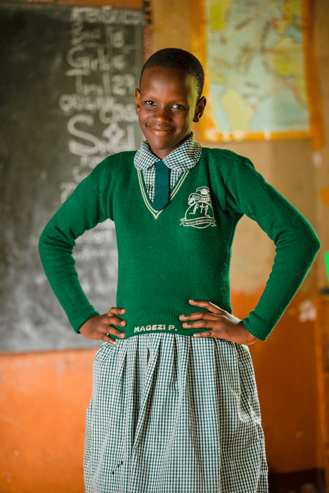 Pamellah stands with her hands on her hips, smiling