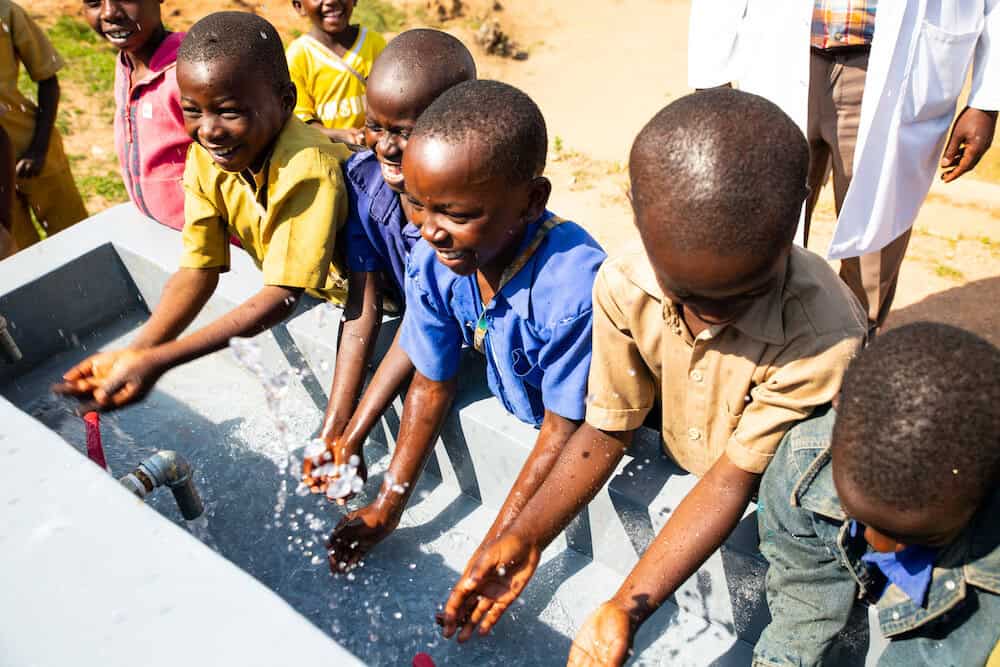 Smiling kids washing their hands in a hand-washings tation