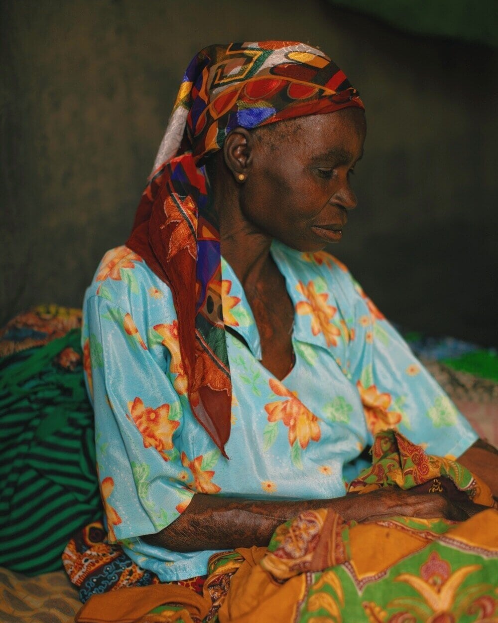 beautiful woman wearing a colorful scarf looks down at her hands