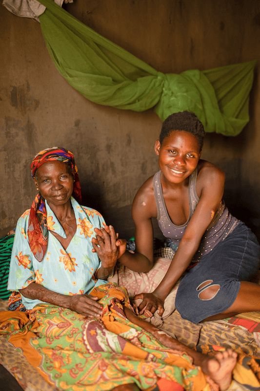 two malawian women sitting and smiling