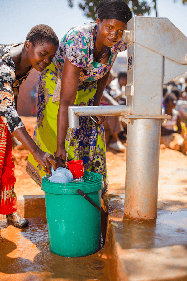 Women drawing clean water from a well in africa