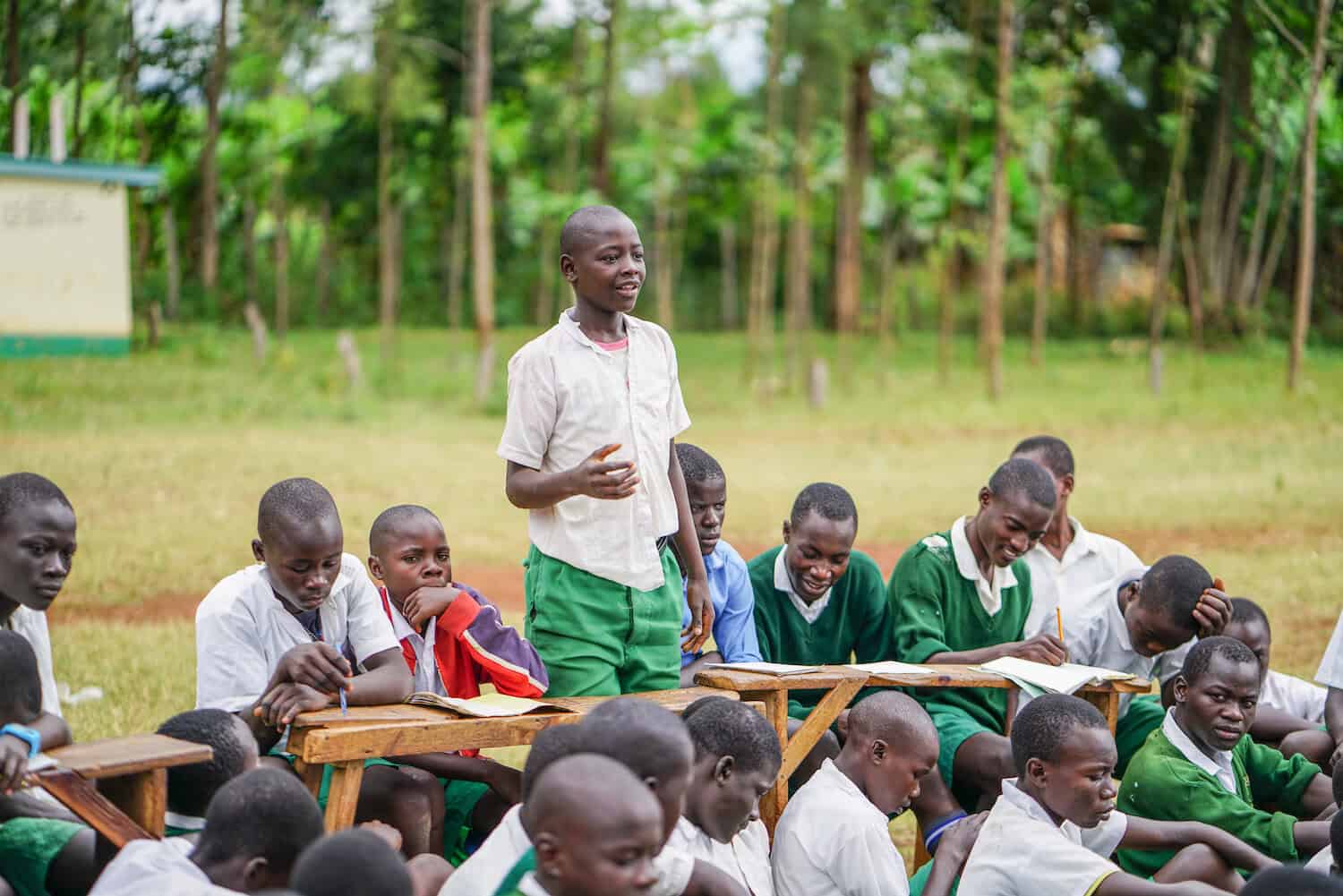 school boy standing in front of other schoolmates