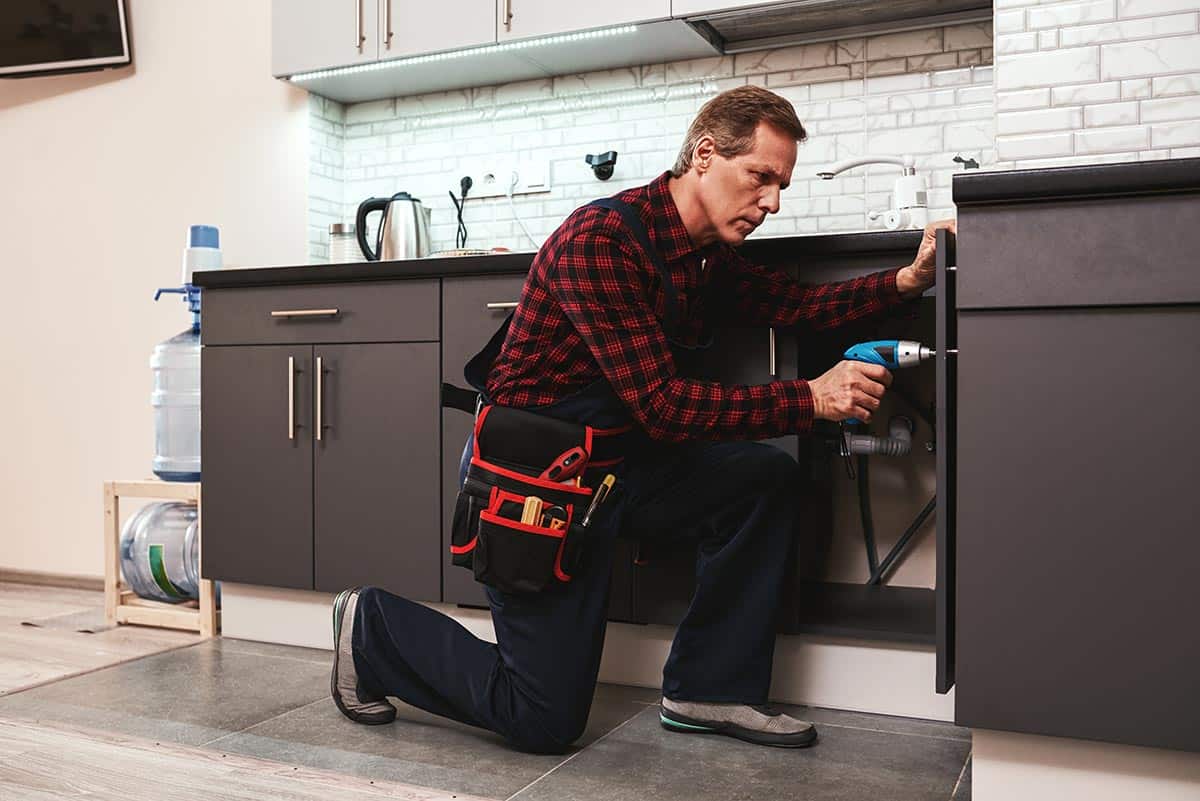 handyman at work repairing kitchen shelves by per resize.jpg
