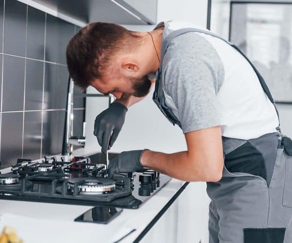 young professional plumber in grey uniform working resize.jpg