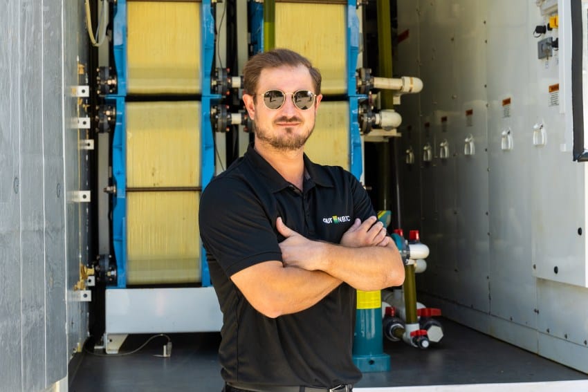 Joshua watts stands in front of iron flow battery