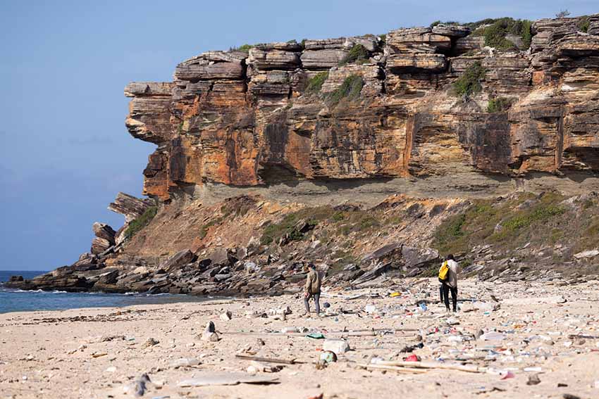 A wide angle shot of a beach covered in debris.