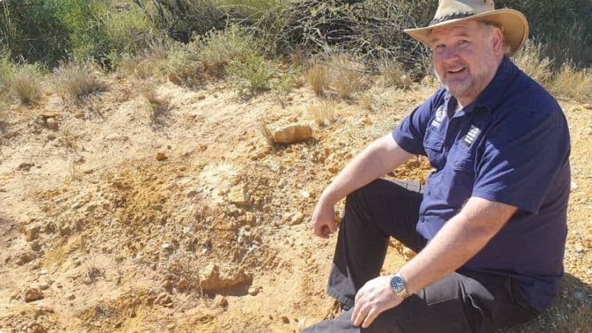 Person sits at dig smiling