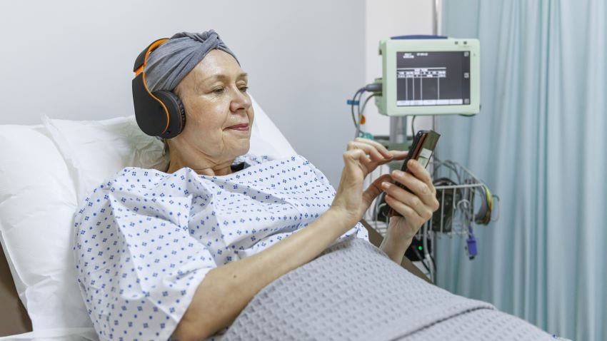 Person in hospital room listening to music through headphones