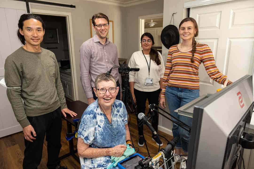 Four researchers standing near research participant in mobility scooter