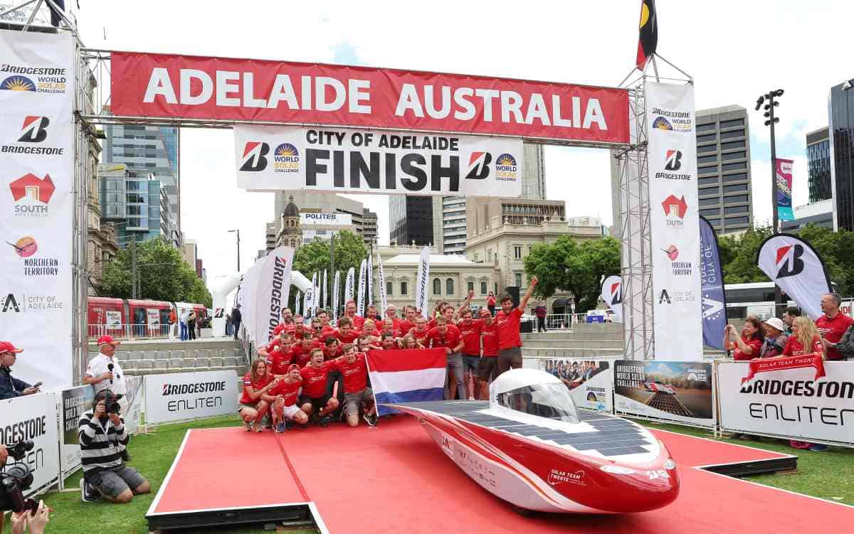 A solar car team celebrates on the finish line