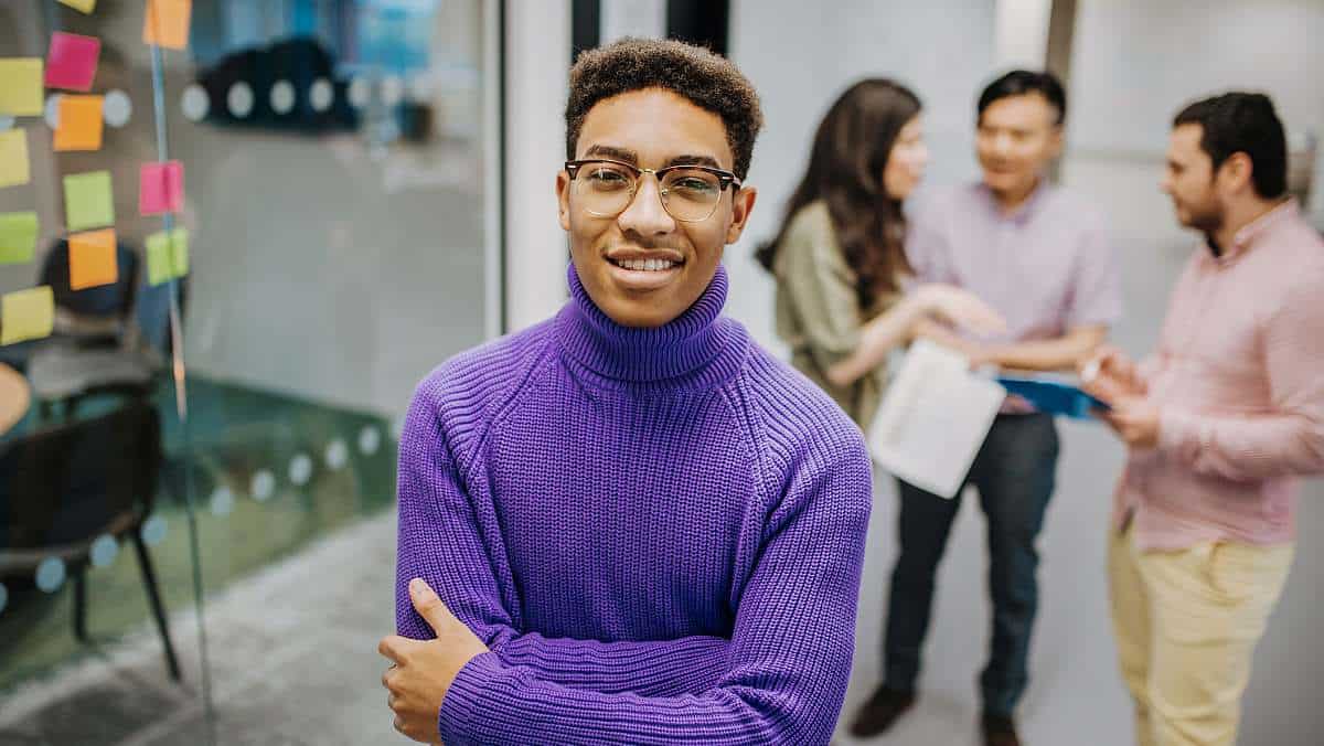 A happy, confident postgraduate student developing research project ideas with their team.