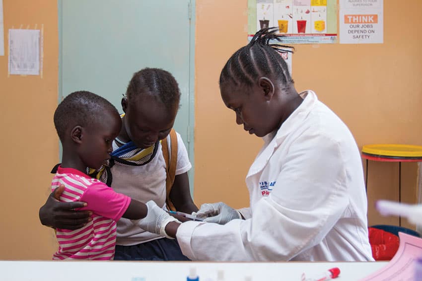 A doctor gives a young boy an injection.