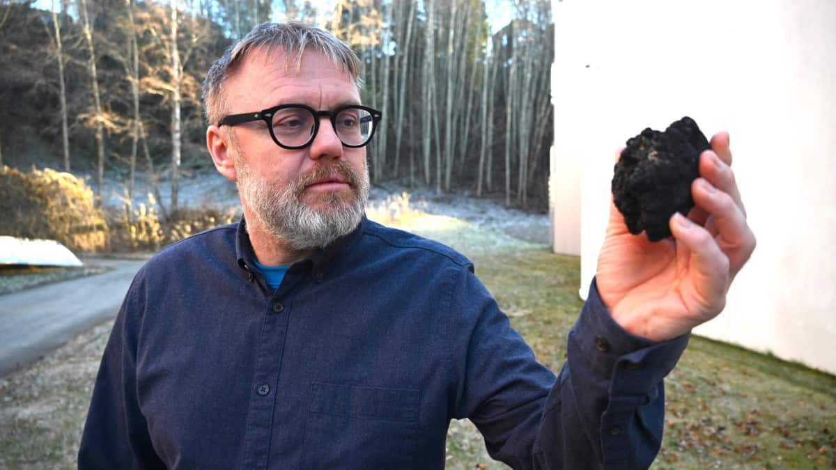 A man holds a black rock