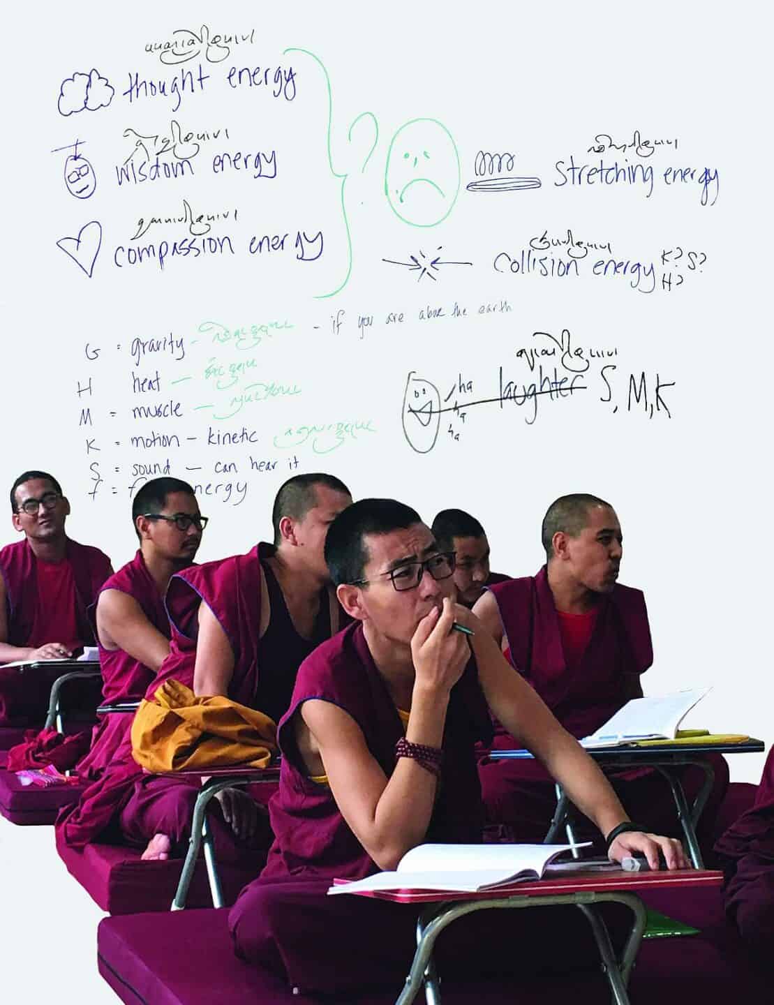 A group of monks sit in the classroom.