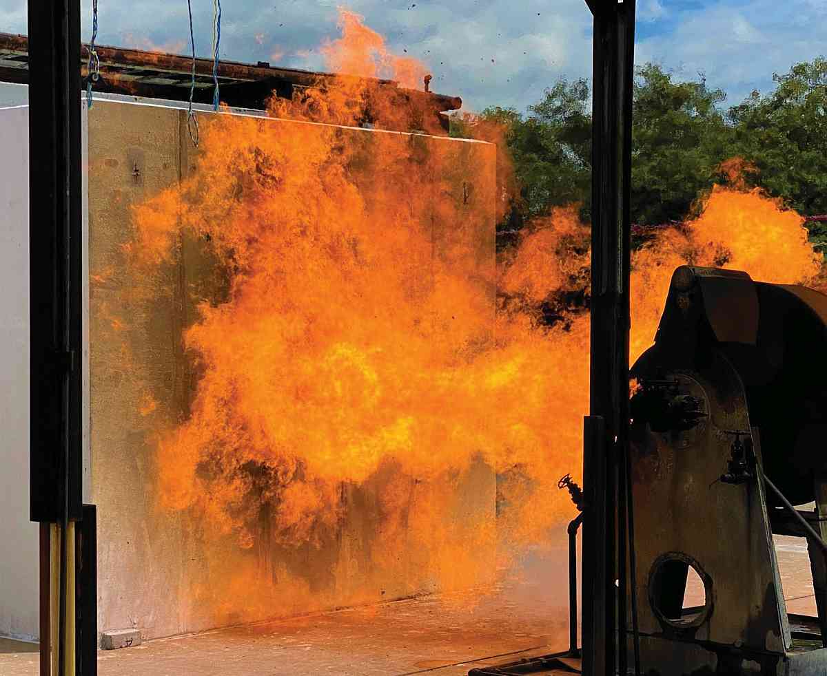 A grey box the size of a bathroom is blasted with flame.