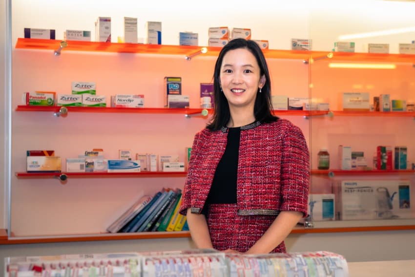 Person standing in pharmacy smiling at camera