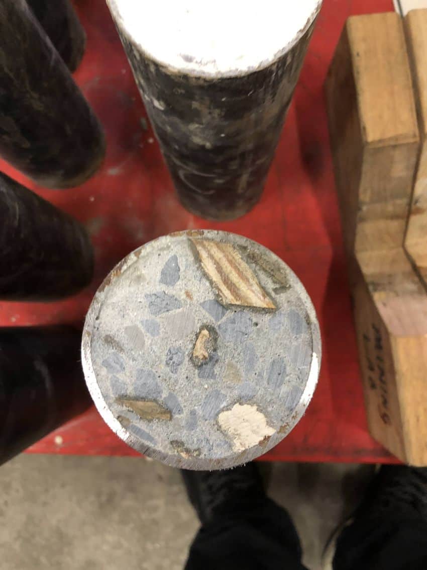 Concrete pole with wood chips visible in cross-section