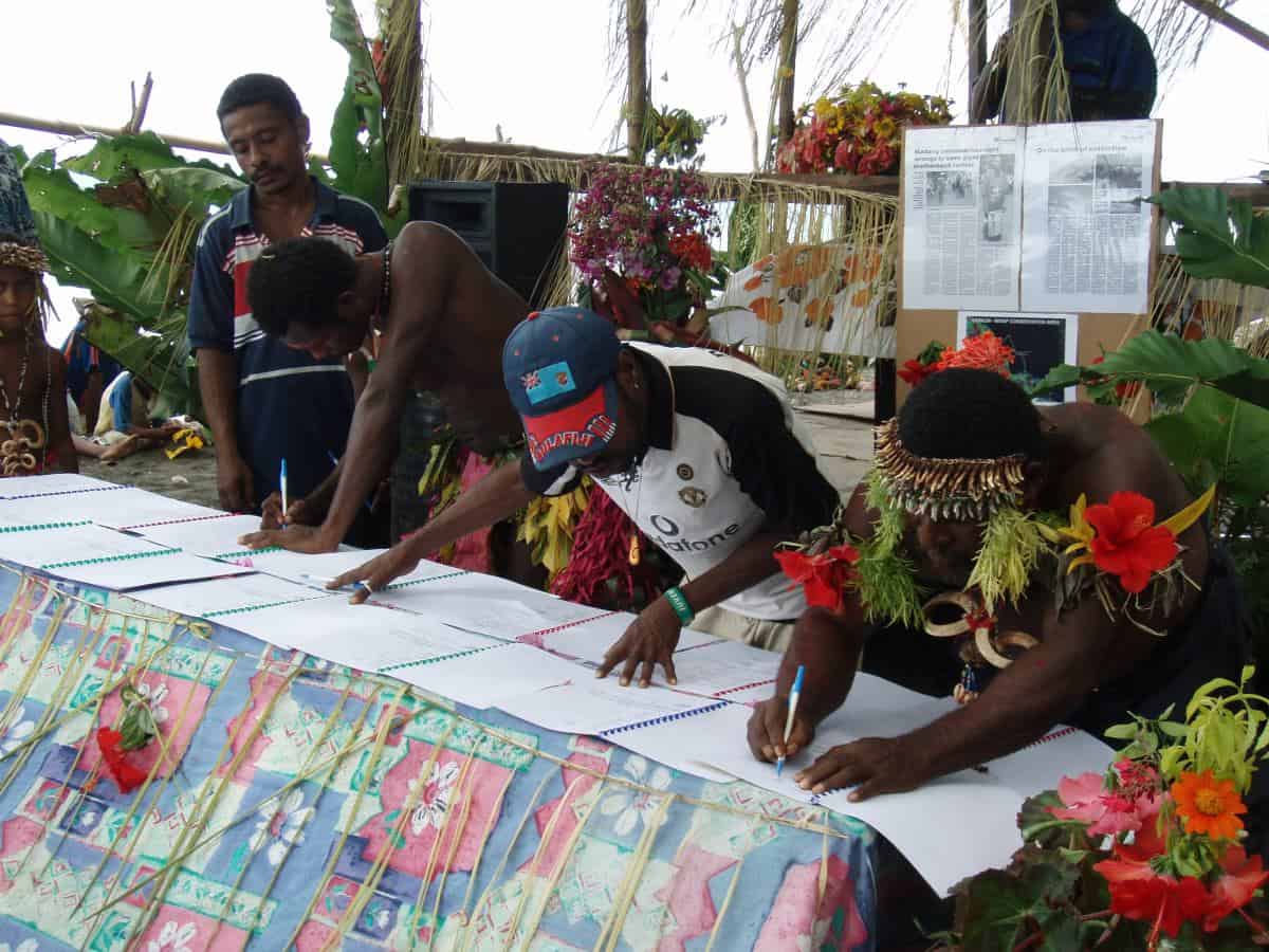 People signing an agreement.