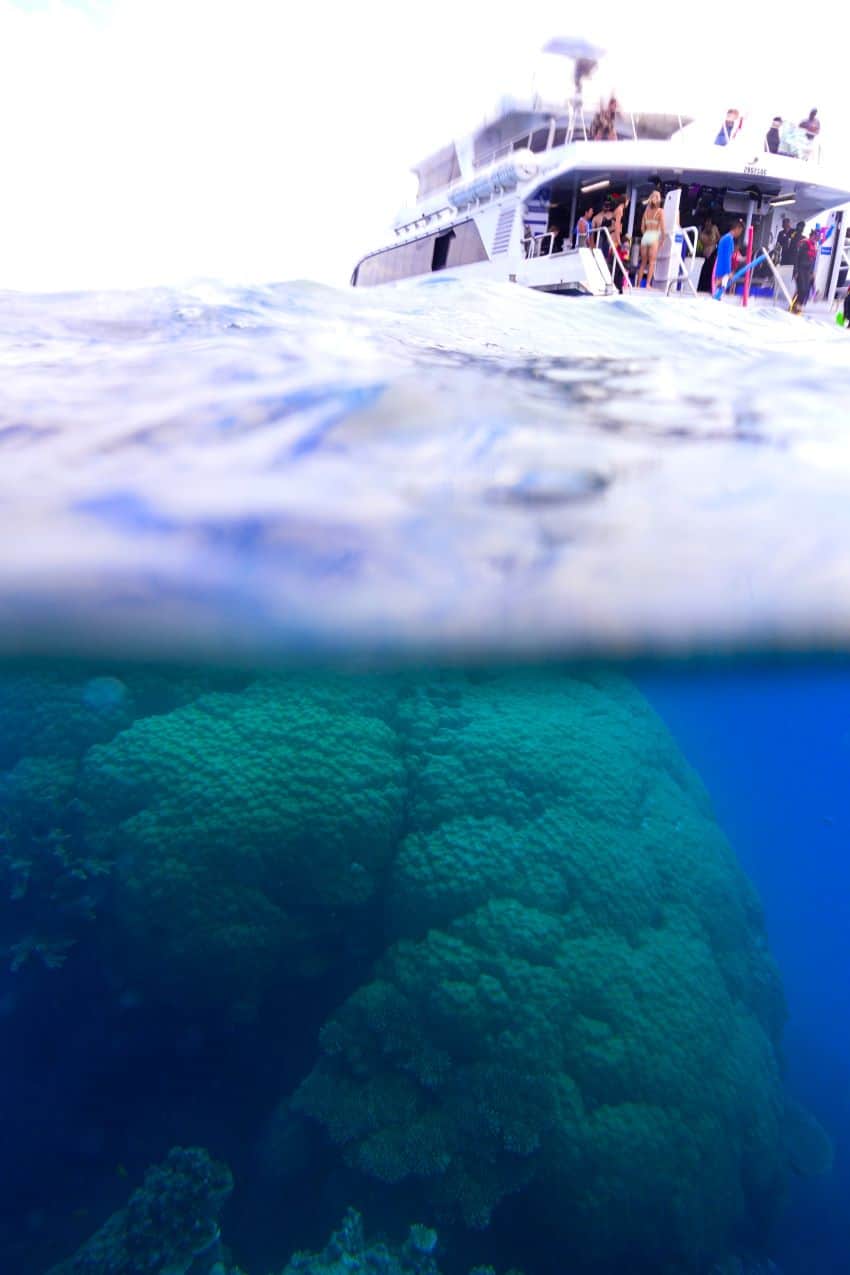 Shot of boat above water and coral underwater