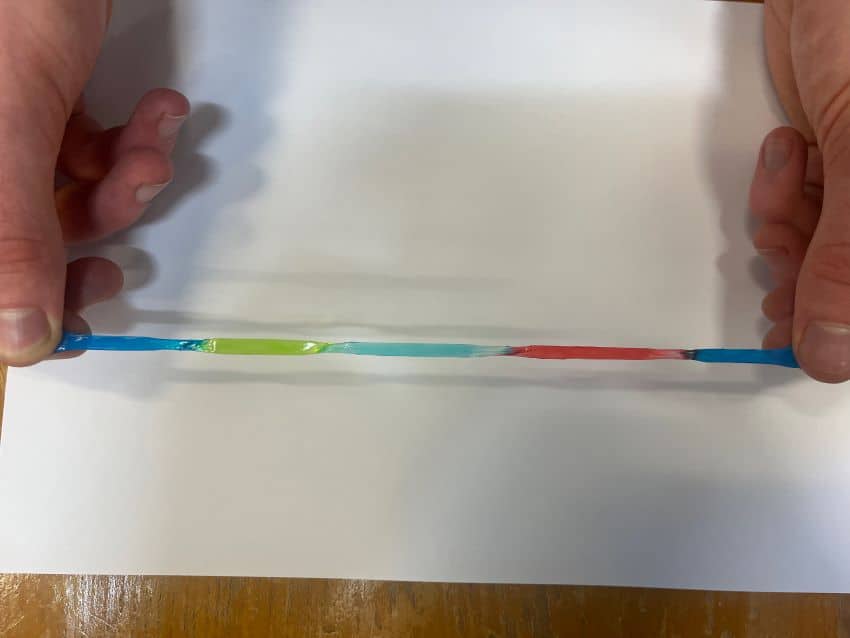 Stretchy coloured gel being pulled between two hands