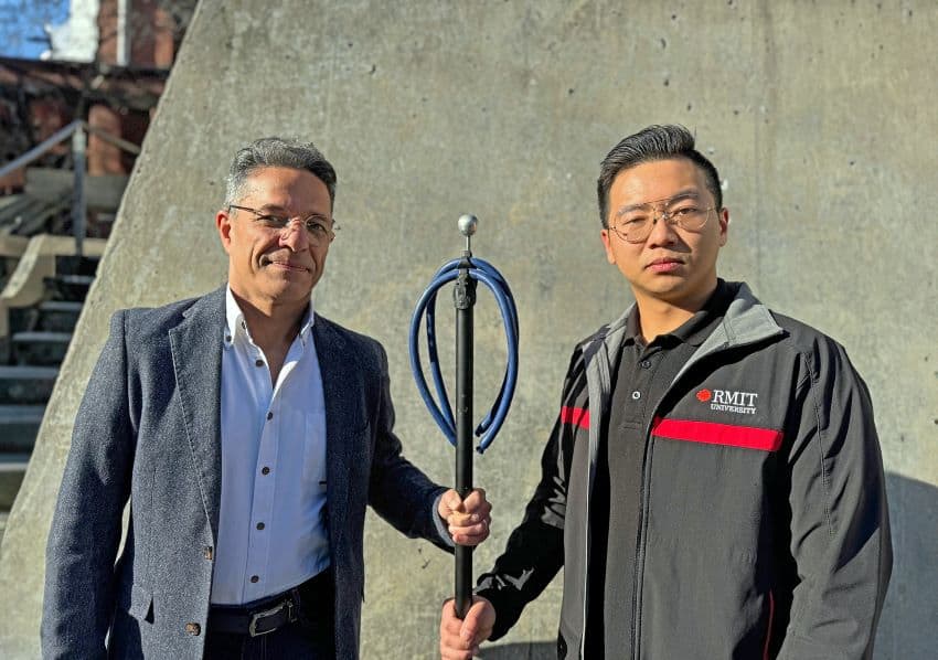 Two people holding speargun device