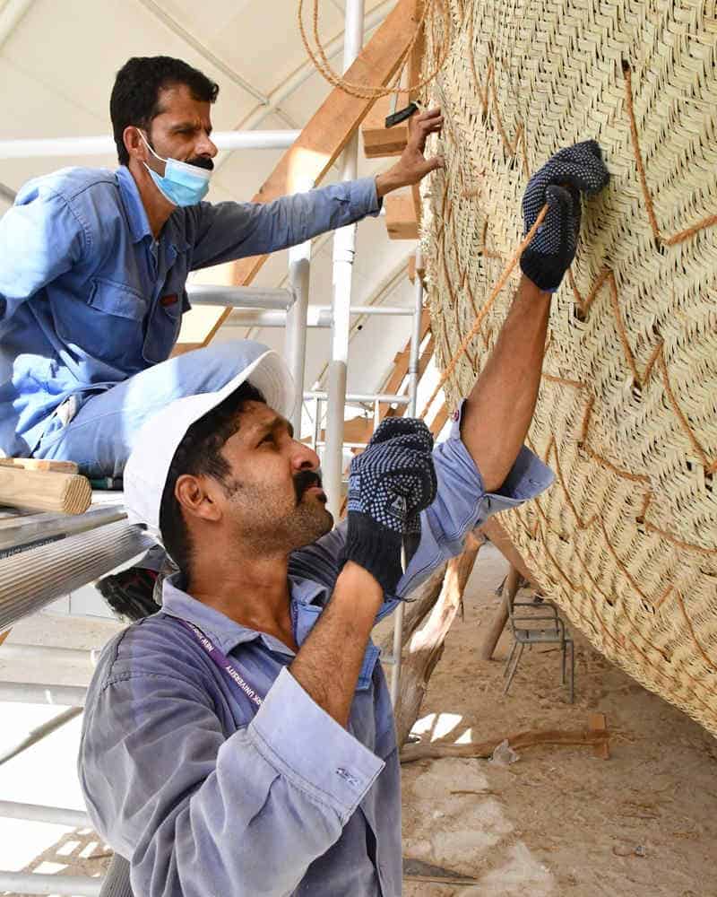 Workers building ancient boat