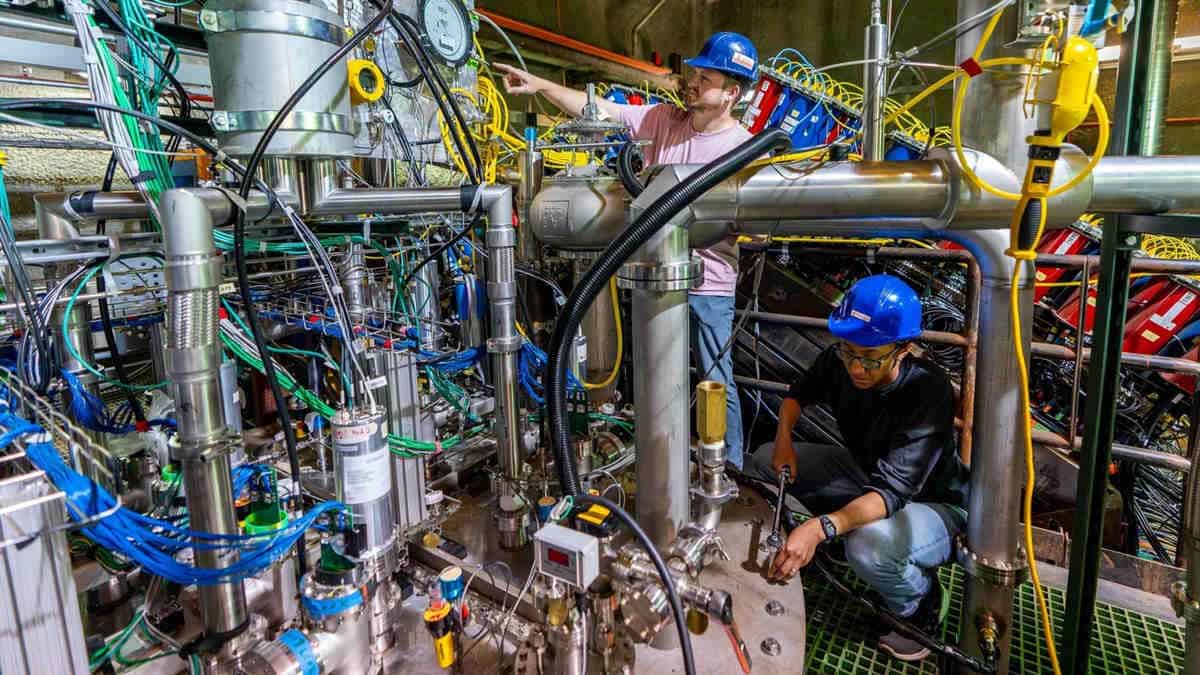 Scientists working on complicated machinery lab experiment dune particle accelerator