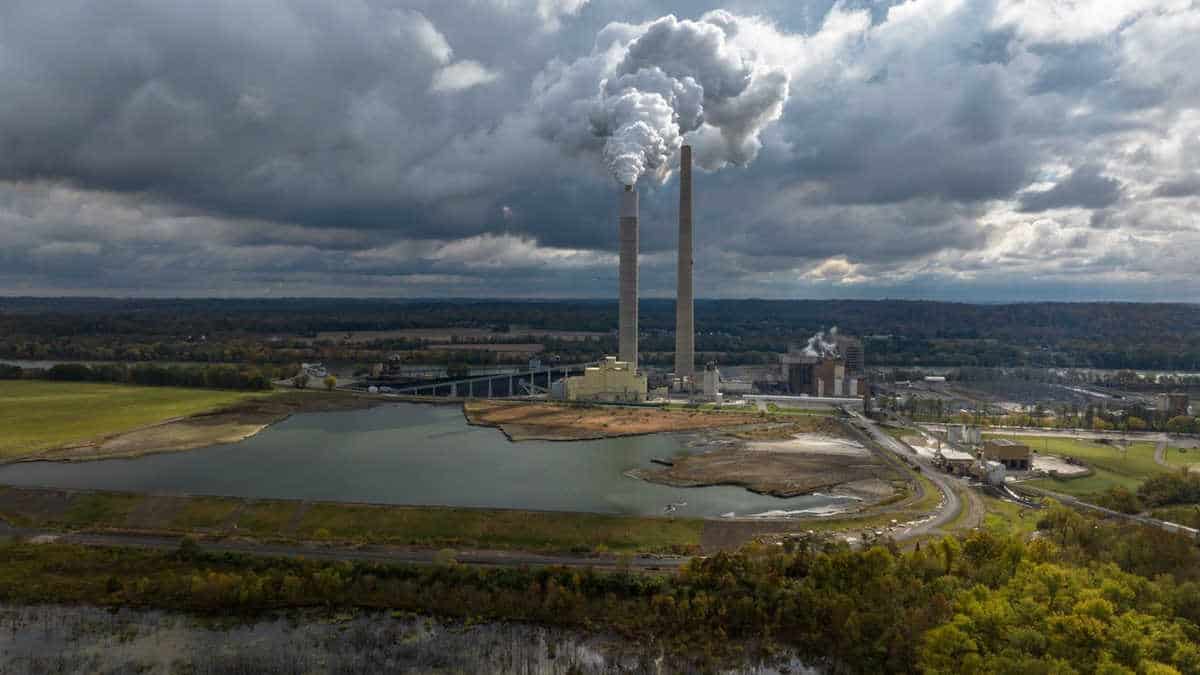Aerial shot of coal power plant chimney emitting smoke on overcast day in cheshire, ohio