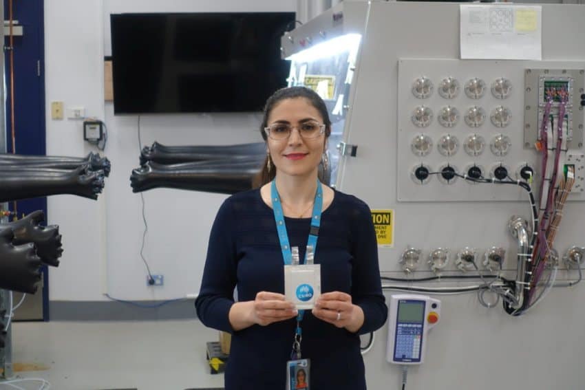 A woman with a csiro lanyard on stands in a laboratory