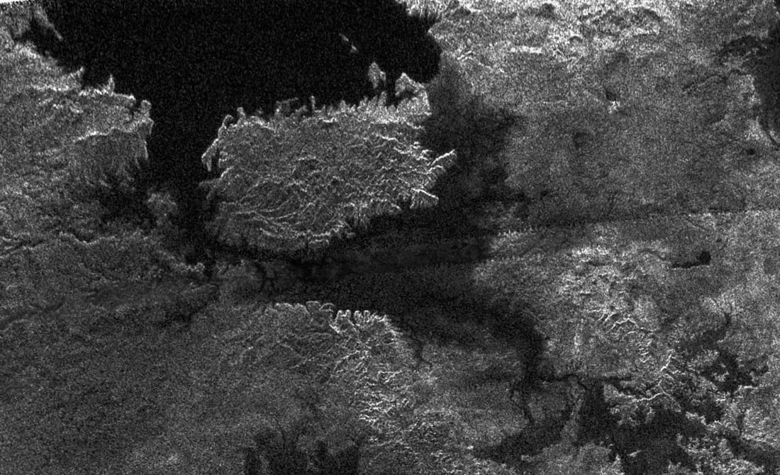Grey grainy image of lake on titan