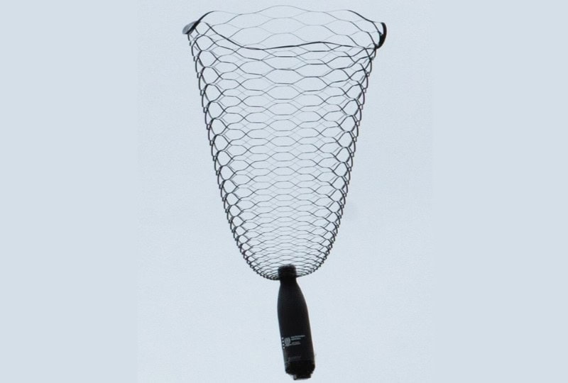 A water bottle hangs under a bell-shaped, net-like parachute