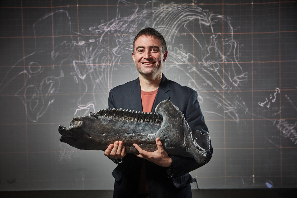 Man holding a large fossil.