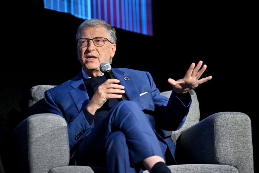 Bill gates in a blue suit sitting and speaking into a microphone. Top role model?