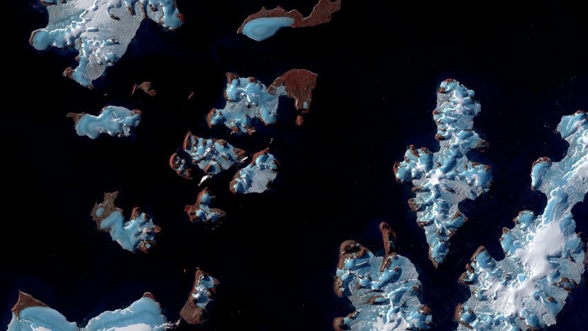 A bird's-eye view of a series of islands covered in ice and snow