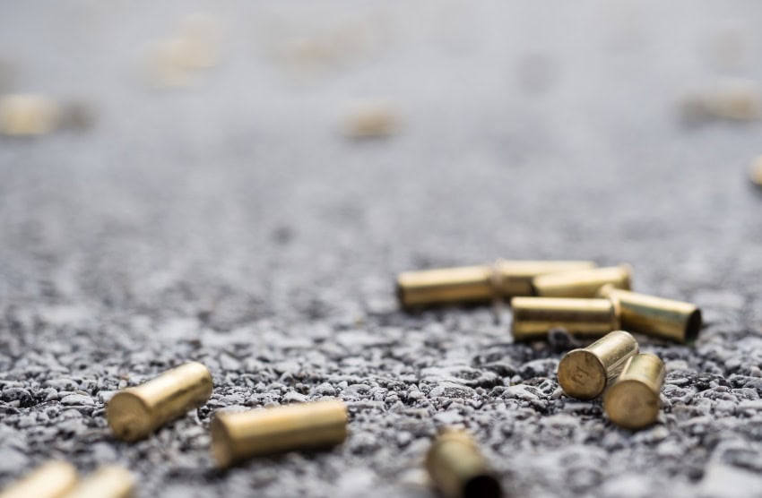 Several bullet casings lying on asphalt