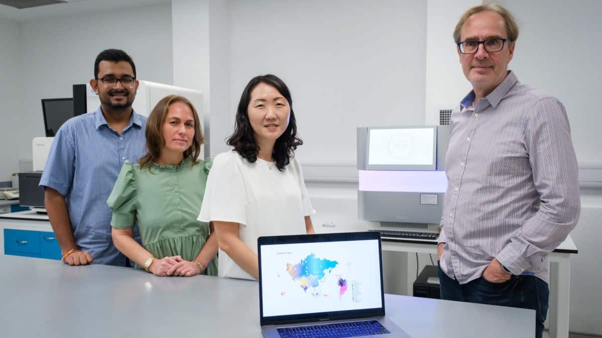 Researchers in a lab with laptop on bench