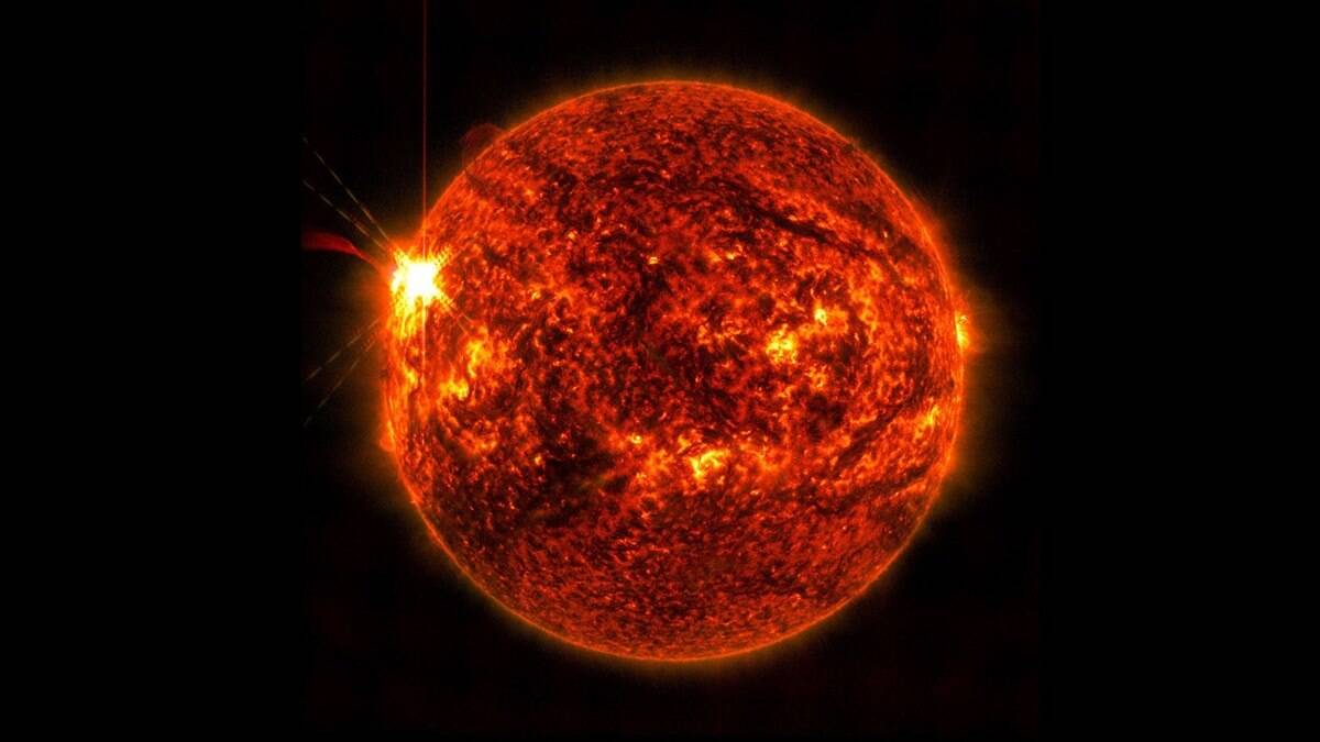 Image of sun in red on black background with solar flare on left