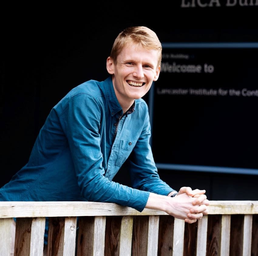 Headshot of dr tim lamont wearing a blue shirt and leaning on the railing.