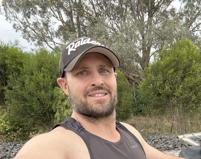 Bearded man wearing a raiders cap and singlet