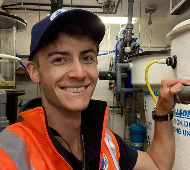 Young man in cap and orange vest in cold room