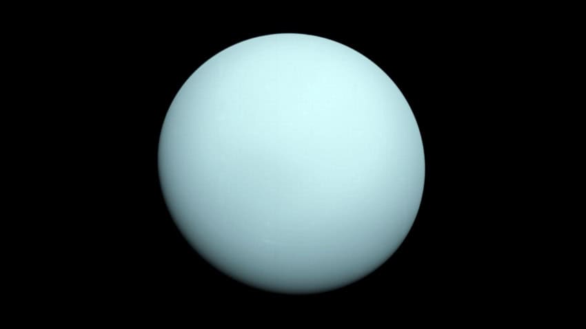 A photograph of the planet uranus. The spherical planet is uniformly pale, icy blue in colour